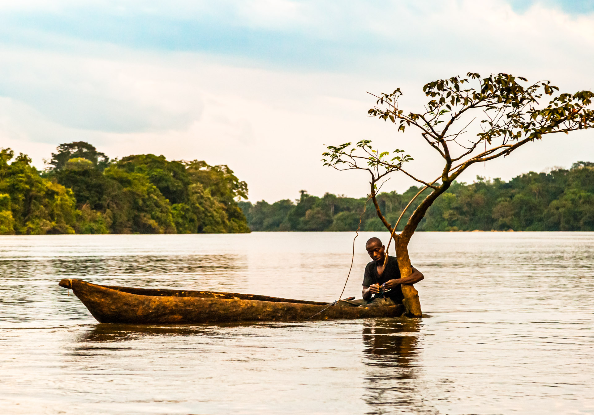 Fisherman in canoe on Moa River, Sierra Leone
