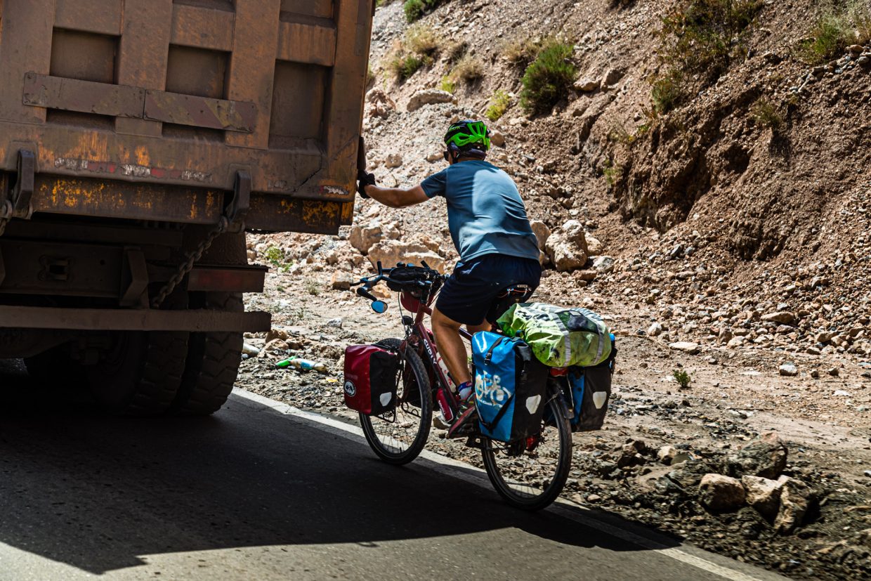 Cyclist being pulled by Van up a Mountain Pass near Takfon, Tajikistan