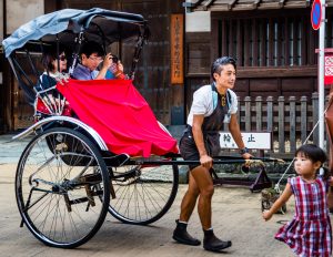City guide with tourists on rickshaw in Tokyo, Japan