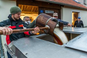 Traditional Zoigl Brewery. The Zoigl original wort is lively filled into the tanker with traditional wooden buckets in Falkenberg, Germany